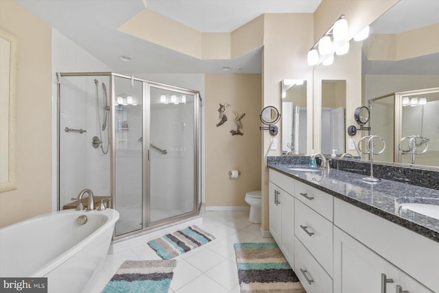 bathroom featuring double vanity, toilet, a freestanding bath, a shower stall, and a sink