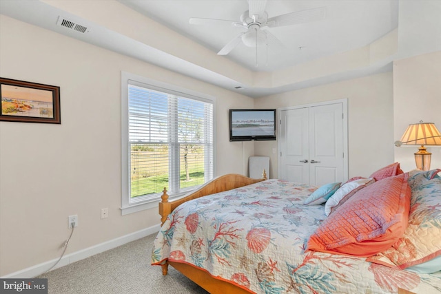 bedroom with visible vents, a closet, baseboards, a ceiling fan, and carpet