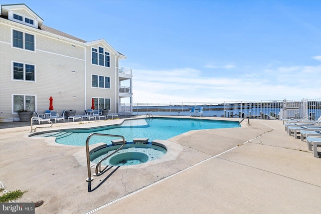 view of pool with a patio, a pool with connected hot tub, and fence