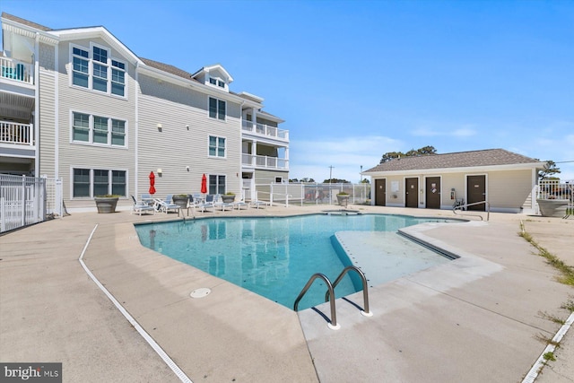 community pool with a patio and fence