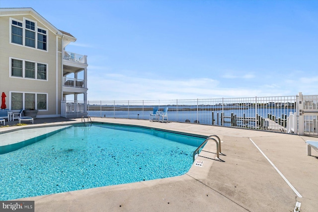 community pool with a patio and fence