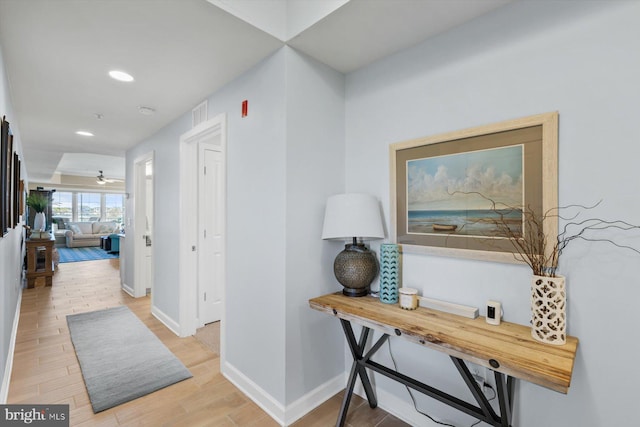 hall featuring baseboards, recessed lighting, light wood finished floors, and visible vents