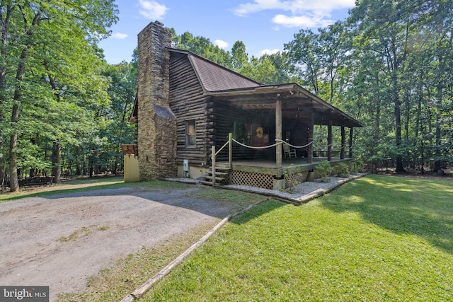 view of home's exterior featuring a chimney, a yard, and log exterior