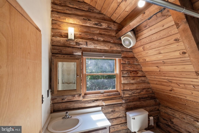 half bathroom featuring a sink, log walls, vaulted ceiling, and toilet