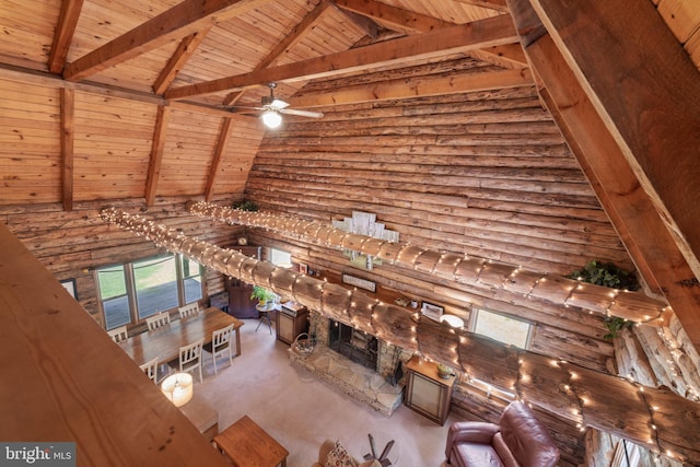 unfurnished living room with high vaulted ceiling, beam ceiling, a healthy amount of sunlight, and wooden ceiling