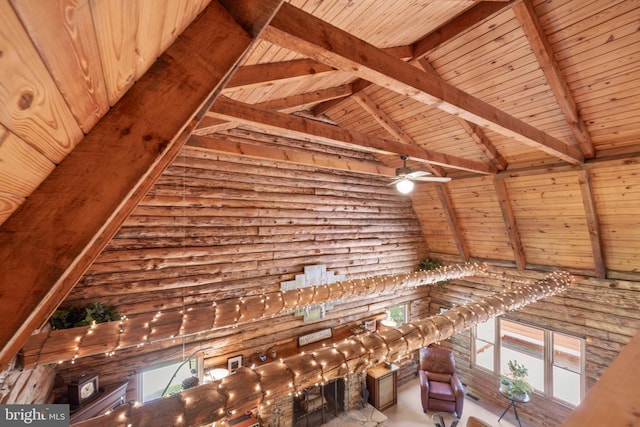 interior space with wood ceiling, beamed ceiling, a ceiling fan, and high vaulted ceiling