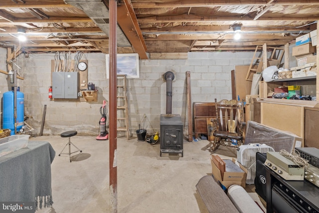 unfinished below grade area with a wood stove and electric panel