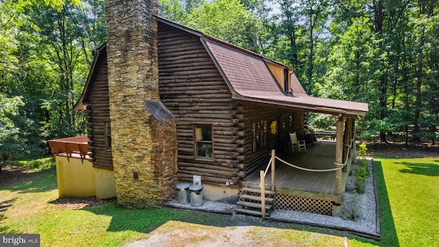 view of property exterior featuring log exterior, a yard, a deck, and a chimney