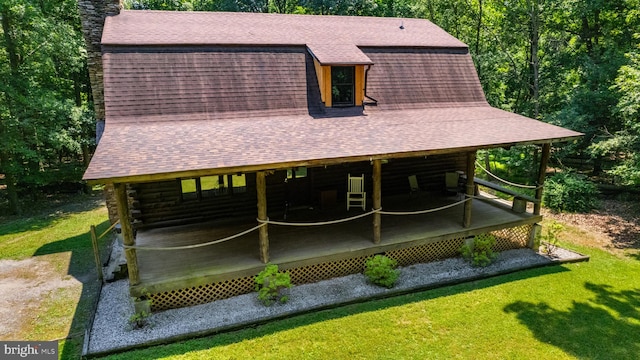 back of property with a lawn, a chimney, and roof with shingles