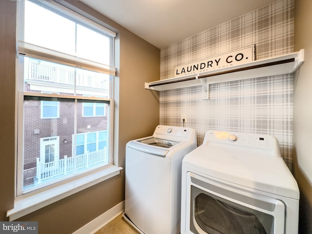 clothes washing area with baseboards, laundry area, wallpapered walls, and washing machine and clothes dryer