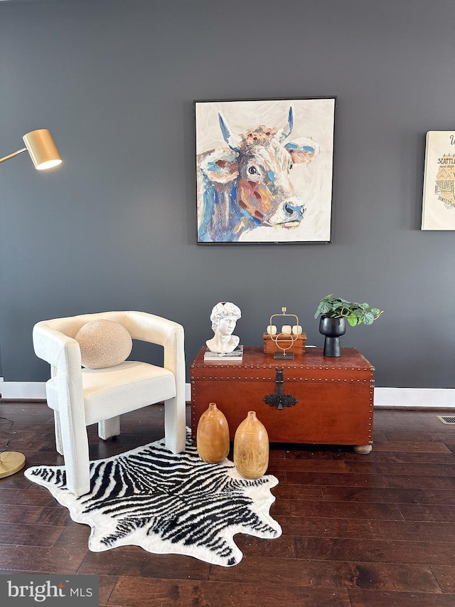 living area featuring baseboards and hardwood / wood-style floors