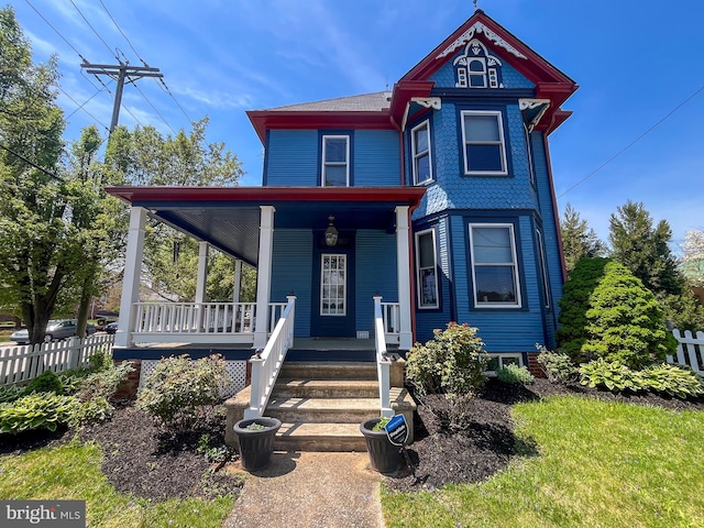 victorian-style house with covered porch and fence