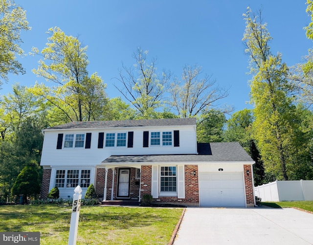 traditional home with a garage, a front lawn, fence, and driveway