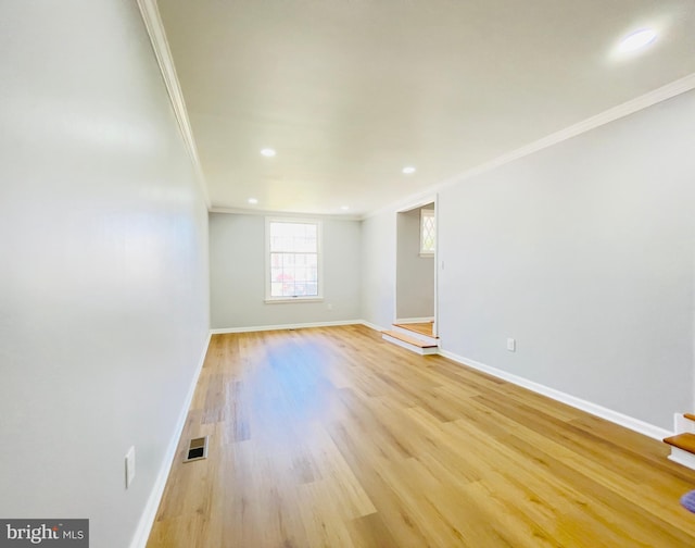 spare room featuring crown molding, baseboards, and visible vents