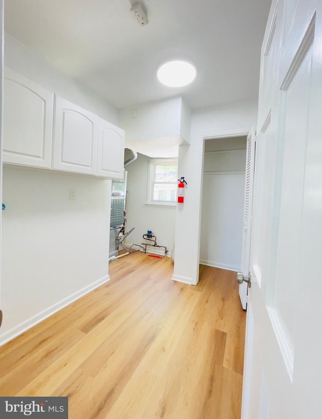 laundry area featuring baseboards and light wood-style floors