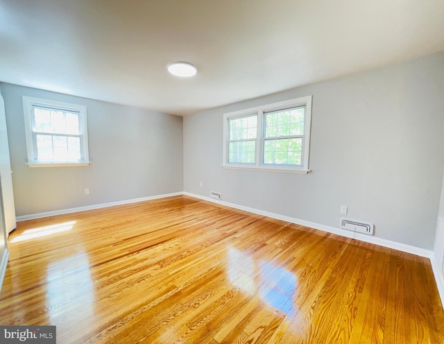 unfurnished room with baseboards and light wood finished floors
