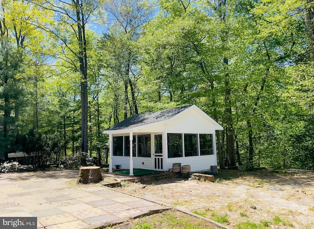 rear view of property featuring a sunroom