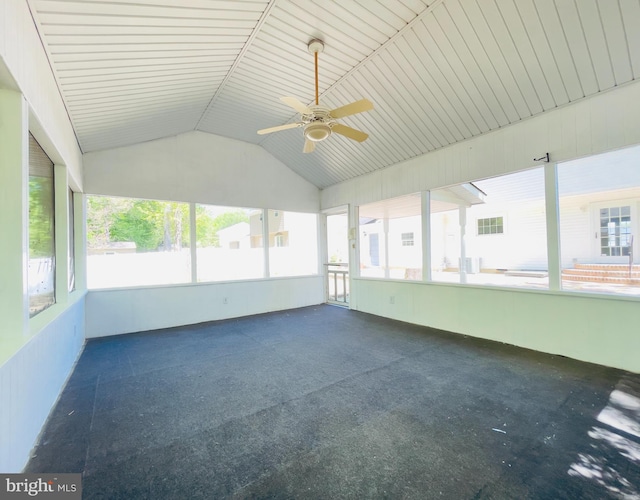 unfurnished sunroom featuring a ceiling fan, carpet flooring, and lofted ceiling