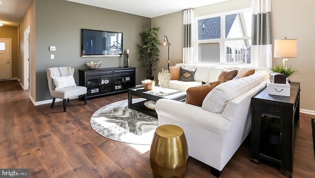 living area featuring baseboards and dark wood-style floors