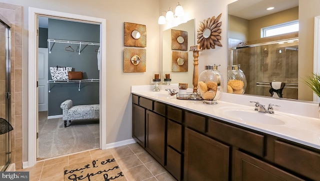 full bath featuring a sink, a walk in closet, a stall shower, and double vanity
