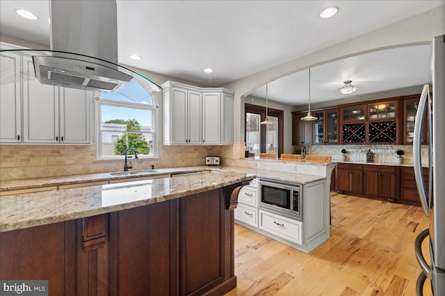 kitchen featuring a sink, stainless steel appliances, island range hood, healthy amount of natural light, and recessed lighting