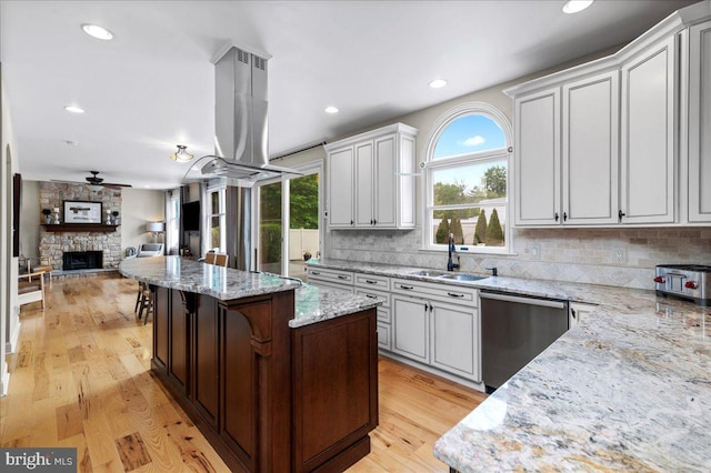 kitchen with dishwasher, a sink, island exhaust hood, a ceiling fan, and a center island