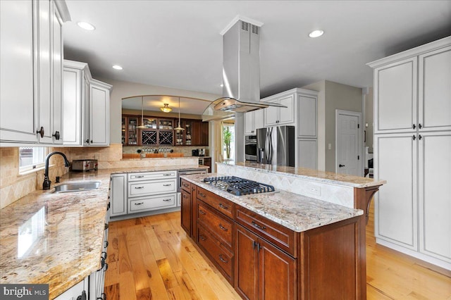 kitchen with stainless steel appliances, island exhaust hood, decorative backsplash, a sink, and a kitchen island