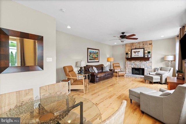 living area featuring a ceiling fan, a fireplace, wood finished floors, and recessed lighting