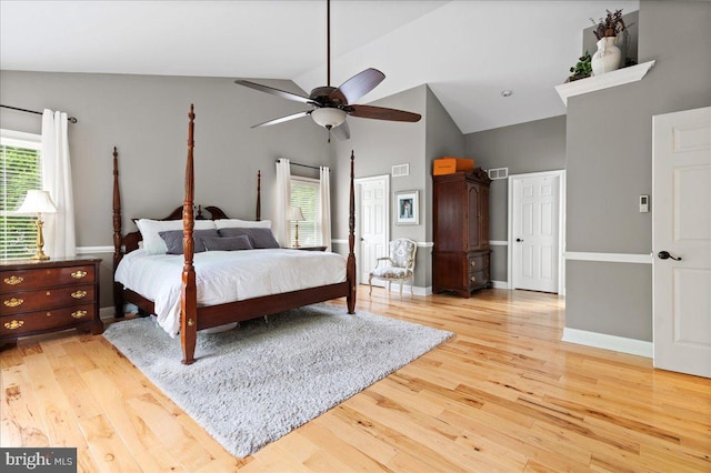 bedroom with high vaulted ceiling, light wood-type flooring, baseboards, and a ceiling fan