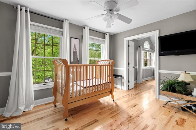 bedroom with multiple windows, light wood-style flooring, and baseboards