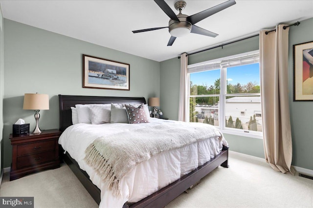 bedroom featuring light colored carpet, baseboards, and ceiling fan