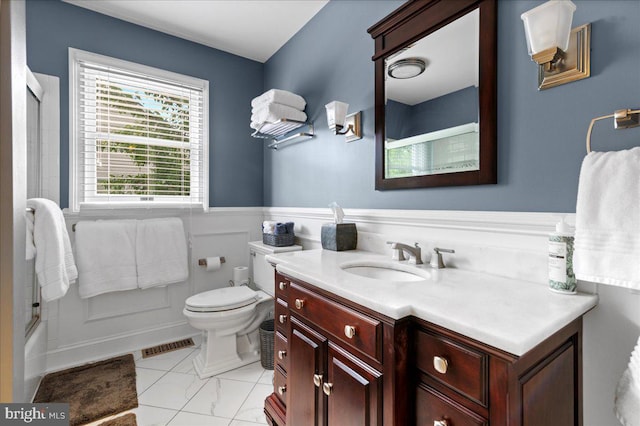full bathroom featuring wainscoting, vanity, toilet, and  shower combination