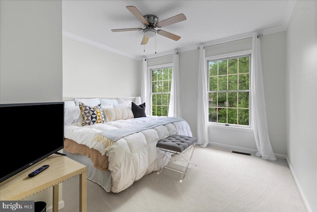 bedroom featuring baseboards, carpet floors, crown molding, and a ceiling fan
