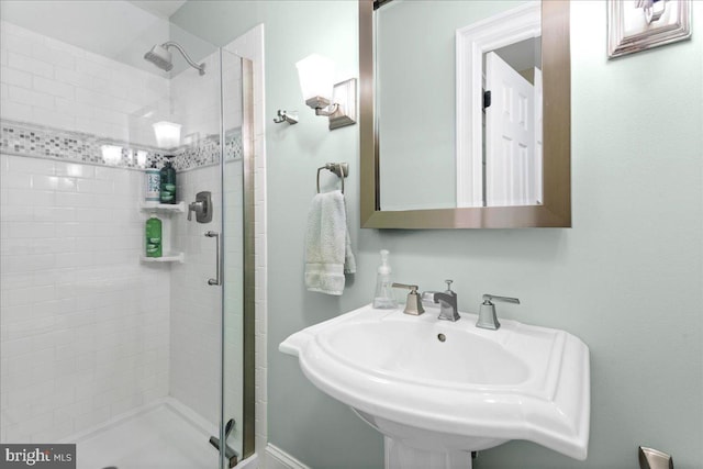 bathroom featuring a shower stall and a sink