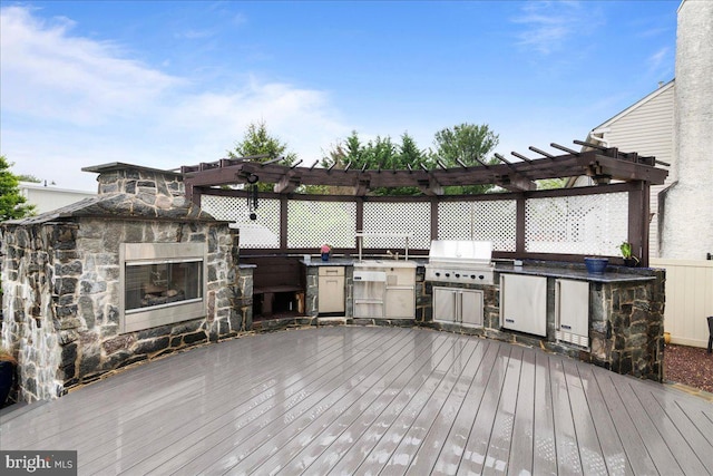 view of patio / terrace with exterior kitchen, grilling area, a wooden deck, and a pergola