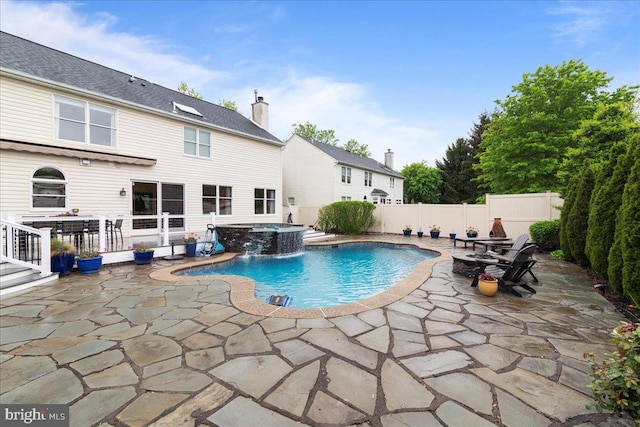 view of pool with a patio, a fenced backyard, and a pool with connected hot tub