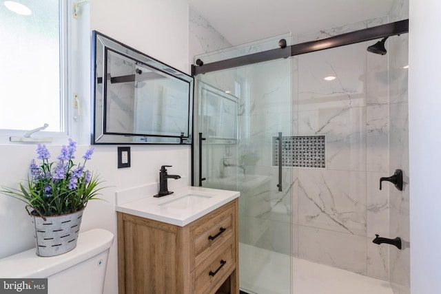 full bathroom featuring a marble finish shower, vanity, and toilet