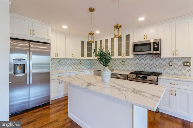kitchen featuring decorative backsplash, stainless steel appliances, and white cabinetry
