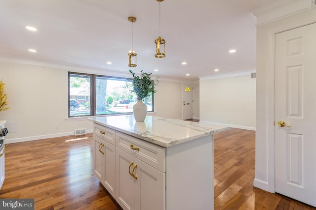 kitchen with crown molding, recessed lighting, light wood finished floors, and visible vents