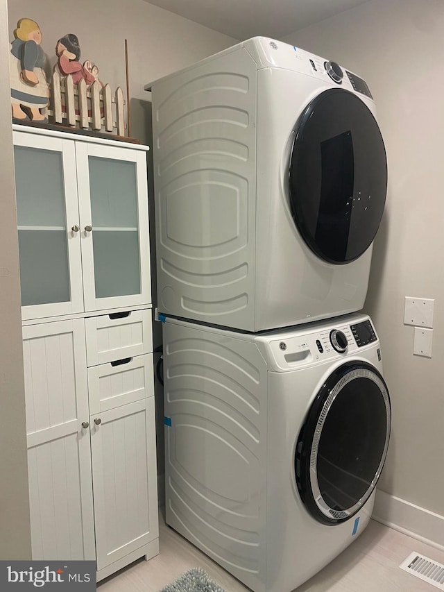 3 Talbot Ave, Cambridge, MD 21613 - washroom featuring cabinet space, stacked washer and clothes dryer, and baseboards