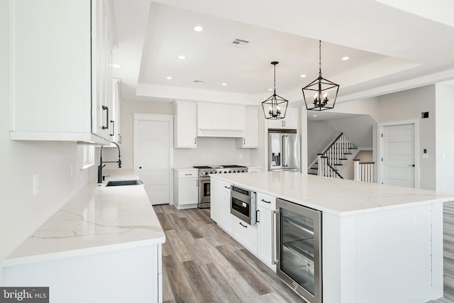 339 11th, Ship Bottom, NJ 08008 - kitchen featuring beverage cooler, appliances with stainless steel finishes, a raised ceiling, light wood finished floors, and recessed lighting