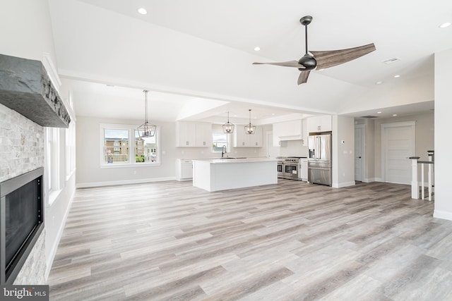 339 11th, Ship Bottom, NJ 08008 - unfurnished living room with a fireplace, a ceiling fan, a sink, light wood-style floors, and lofted ceiling