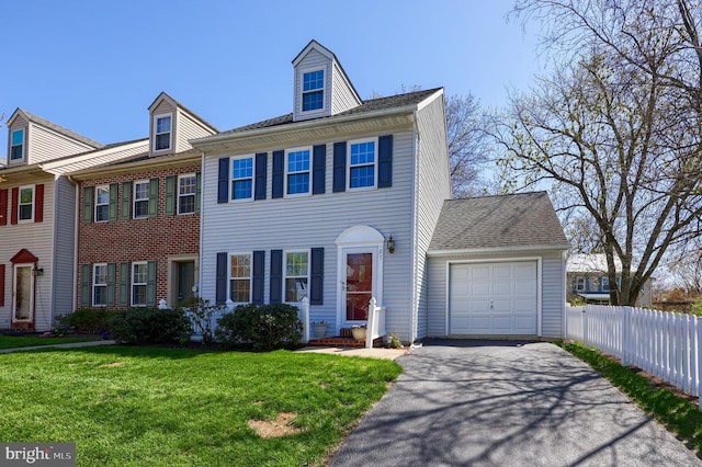 multi unit property featuring a garage, fence, a front yard, and aphalt driveway