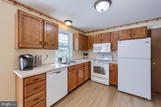 kitchen featuring light countertops, light wood-style floors, white appliances, and brown cabinetry