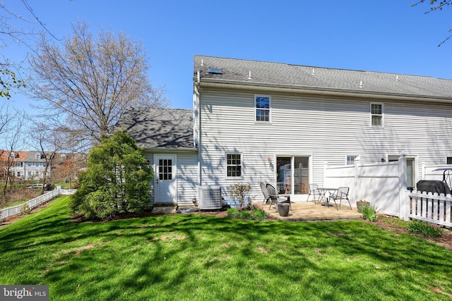 rear view of house featuring fence, a lawn, cooling unit, and a patio area