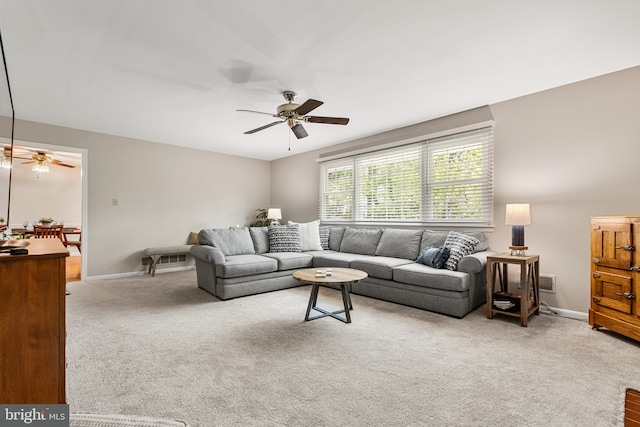 carpeted living room with baseboards and a ceiling fan