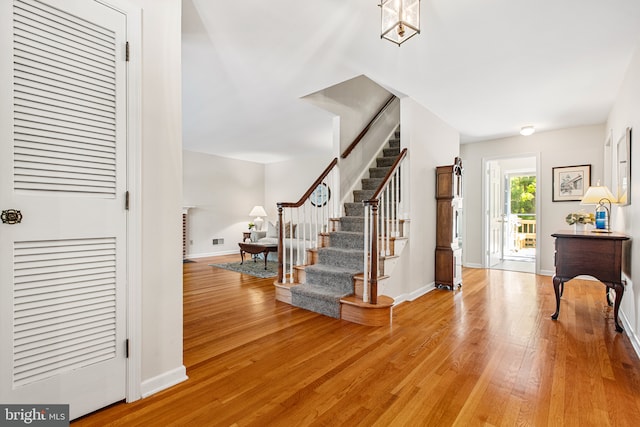 entrance foyer with stairs, baseboards, and light wood-style floors