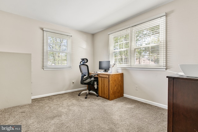carpeted office space featuring baseboards and plenty of natural light
