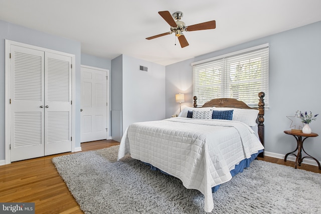bedroom with baseboards, wood finished floors, and a closet