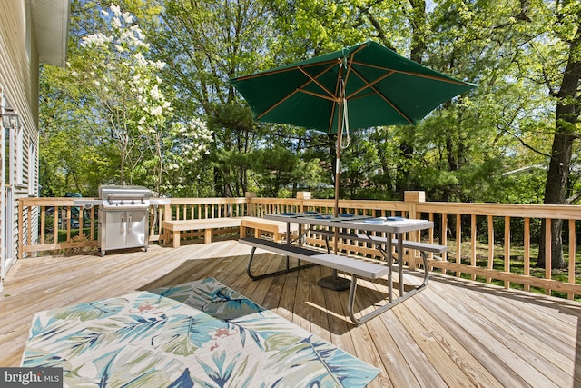 deck featuring outdoor dining space and area for grilling
